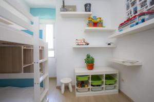 Habitación de juguete con litera y estanterías en SingularStays El Puig Beach II, en Las Canteras
