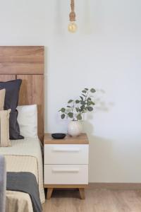 una camera con un letto e un comodino con una pianta di VLC HOST - Reino a Valencia