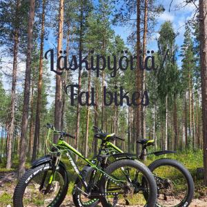 two bikes parked in front of a sign in a forest at Arctic Circle Beach House in Meltosjärvi