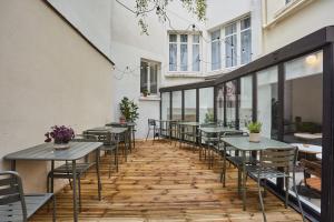 una fila de mesas y sillas en un patio en Hôtel Beauquartier Montmartre, en París