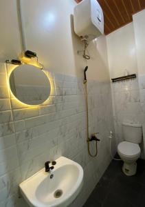 a white bathroom with a sink and a toilet at Et Malio Stay & Travel in Sentool