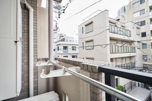 einen Balkon mit Blick auf ein Gebäude in der Unterkunft WINBELL DUET Ebisu5 in Tokio