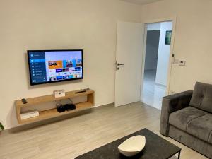a living room with a couch and a flat screen tv at ANET Apartman Visoko in Visoko