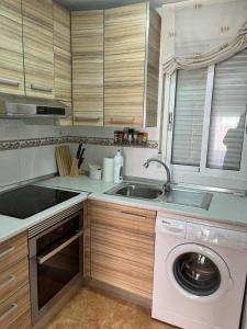 a kitchen with a washing machine and a sink at Almuden's yellow apartment, HIGH-SPEED FREE WIFI, 250m to Beach, The center of Torrevieja in Torrevieja
