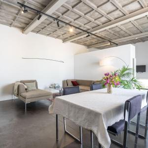 a room with a table and chairs and a couch at Loft van 90 m² met grote binnentuin. in Antwerp