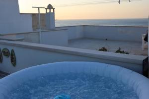 een hot tub op een patio met uitzicht op de oceaan bij House with Amazing Sea View in Polignano a Mare