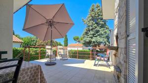 eine Terrasse mit Tisch und Sonnenschirm in der Unterkunft Casa Elza in Dajla