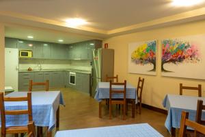 a kitchen and dining room with two tables and a refrigerator at Agroturismo Argoin Txiki in Zarautz
