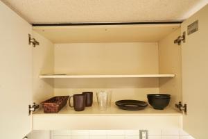 ein Küchenregal mit Schalen und Küchenutensilien darauf in der Unterkunft WINBELL DUET Ebisu5 in Tokio