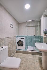a bathroom with a washing machine and a sink at Peregrina Pensión 5 in O Pedrouzo