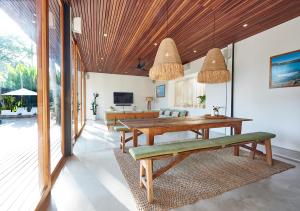 a dining room with a table and a couch at Amazing 3BDR-Villa Canggu/Seseh 2min walk to Beach in Canggu