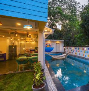 a house with a swimming pool in the backyard at goSTOPS Goa, Baga in Baga
