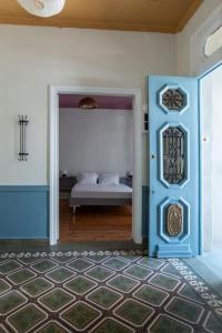 una camera con una porta blu e una camera con un letto di Casanova94 Guesthouse a Pireo