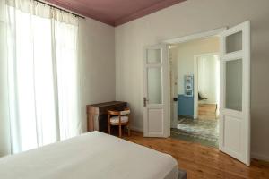 a bedroom with a bed and a door to a hallway at Casanova94 Guesthouse in Piraeus