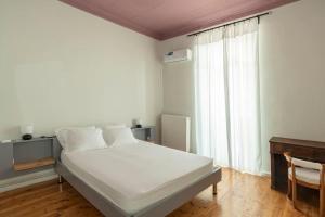 a bedroom with a white bed and a window at Casanova94 Guesthouse in Piraeus