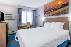 a hotel room with a bed and a television at Days Inn by Wyndham Sioux Falls Airport in Sioux Falls