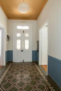 a hallway with a white door and a rug at Casanova94 Guesthouse in Piraeus
