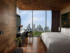 a hotel room with a bed and a view of the city at SO/ Bangkok in Bangkok