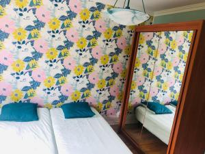 een kamer met 2 bedden en een muur met bloemen bij Sainte Beuve Two, Terrasse Vue Mer in Boulogne-sur-Mer