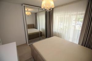 a room with a mirror and a bed and a couch at Luxuriously flat fully equipped quality appliances in Tulcea