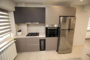 een keuken met een roestvrijstalen koelkast en fornuis bij Luxuriously flat fully equipped quality appliances in Tulcea