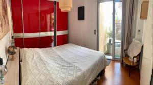 um quarto com uma cama branca e uma parede vermelha em Chambre salle de bain privée avec piscine à 20 minutes de Paris em Fontenay-sous-Bois