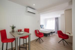 Zimmer mit einem Tisch, roten Stühlen und einem Bett in der Unterkunft Appartements French Riviera Confidential Centre Ville Juan les Pins proche des plages in Juan-les-Pins