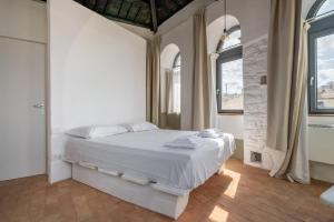 维泰博Torre Subrosa, vasca in camera cromoterapia的一间卧室，有一张白色的床和两扇窗户