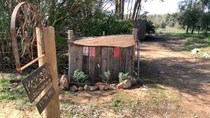 a small wooden shed with a sign next to a fence at Moreson in Nieuwoudtville