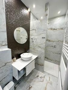 a white bathroom with a sink and a mirror at Rooms Lidija in Zagreb