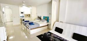 プラヤ・デ・ラス・アメリカスにあるApartment in Paraiso Royalのリビングルーム(ベッド2台付)、キッチンが備わります。