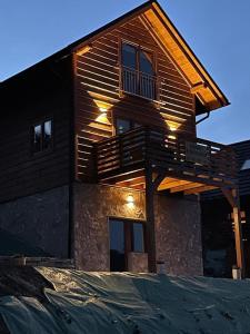 een houten huis met lichten aan de zijkant bij Domki na Szlaku in Brenna