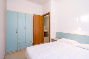 ein Schlafzimmer mit einem großen weißen Bett und einem Spiegel in der Unterkunft Stork Family Camping Village in Giulianova