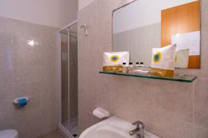 ein Badezimmer mit einem Waschbecken, einem WC und einem Spiegel in der Unterkunft Stork Family Camping Village in Giulianova