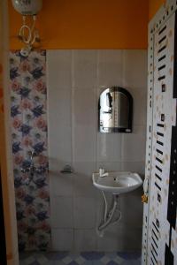 un baño con lavabo y espejo en Geetanjali, en Bolpur