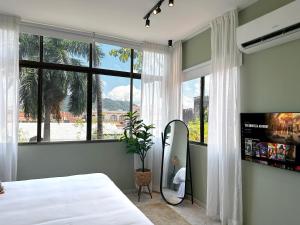 um quarto com uma cama e uma grande janela em Amazinn Places Teatro Nacional na Cidade do Panamá