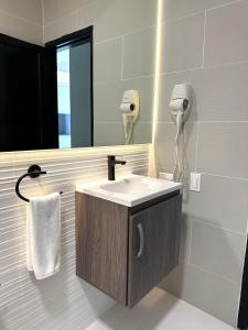 uma casa de banho com um lavatório e um espelho em Amazinn Places Teatro Nacional na Cidade do Panamá