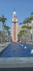 a clock tower and a fountain in front of a building at Nagaland Guesthouse in Hong Kong