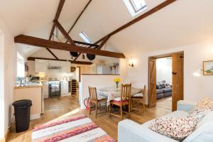 a kitchen and living room with a table and chairs at Dairy Cottage in Roffey