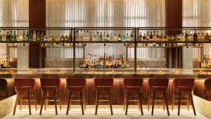 a bar with a bunch of bar stools at Thompson Hollywood, part of Hyatt in Los Angeles