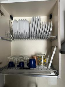 a shelf in a kitchen with plates and glasses at ALLOGGIO STUPINIGI in Nichelino