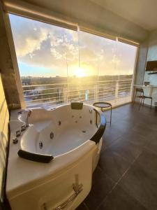 a large bath tub in a room with a large window at Living in Casoria