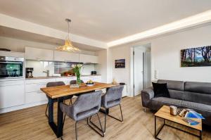cocina y sala de estar con mesa y sofá en FeWo Prora - See(h)nsucht en Binz