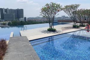 een zwembad met bomen aan de zijkant van een gebouw bij 4room2bath 8guests｜The Mines｜KTM Serdang Lake View in Seri Kembangan