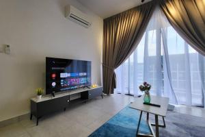 een woonkamer met een grote televisie en een tafel bij 4room2bath 8guests｜The Mines｜KTM Serdang Lake View in Seri Kembangan