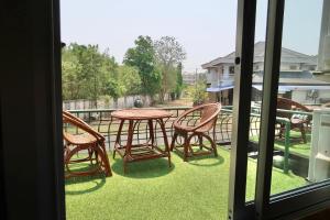 eine Terrasse mit einem Tisch und Stühlen auf dem Rasen in der Unterkunft Vintage54 Hotel Ayutthaya in Phra Nakhon Si Ayutthaya