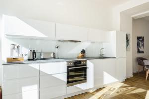 a kitchen with white cabinets and a stove at FeWo Prora - Seaside in Binz