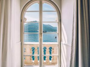 an arched window with a view of the water at Heritage Grand Perast By Rixos in Perast