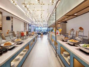 a buffet line in a restaurant with plates of food at ibis Palembang Sanggar in Palembang