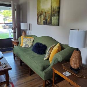 ein Wohnzimmer mit einer grünen Couch mit Kissen in der Unterkunft Bungalow by the Beach in Hampton